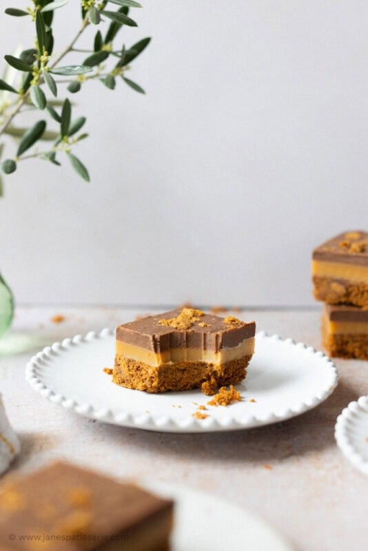 A bite taken from a Biscoff Millionaires on a plate
