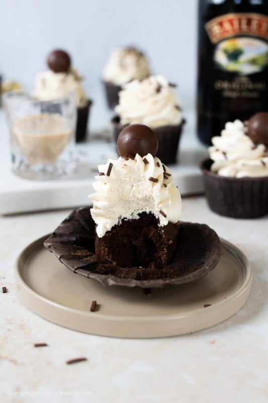 A bite taken from a baileys cupcake on a plate