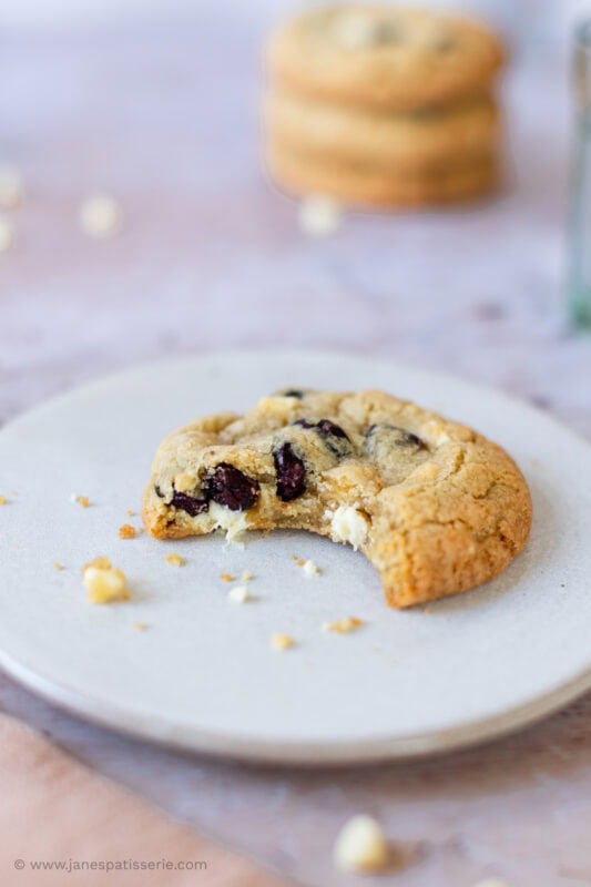 A bite missing from a White Chocolate and Cranberry Cookie