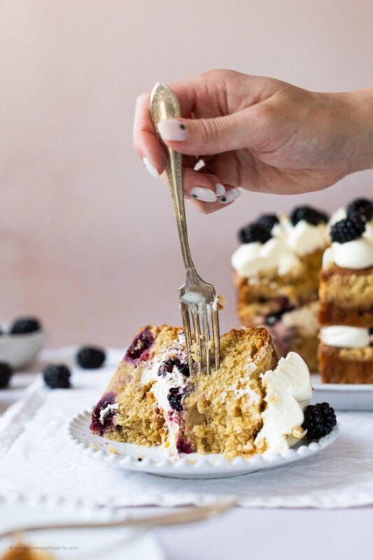 Fork into slice of two-layer apple blackberry cake