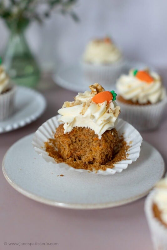 A bite taken from a carrot cake cupcake