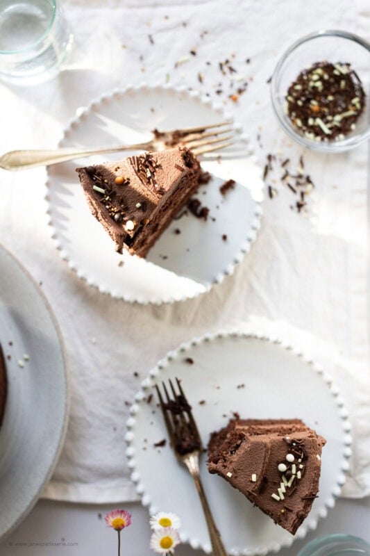 Slices of back to basics chocolate cake on white plates with forks