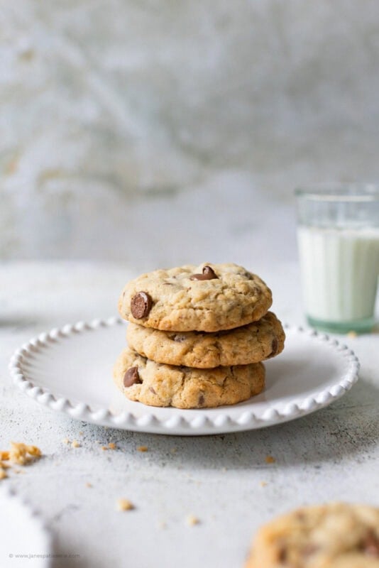A stack of three chocolate oat cookies on a plate