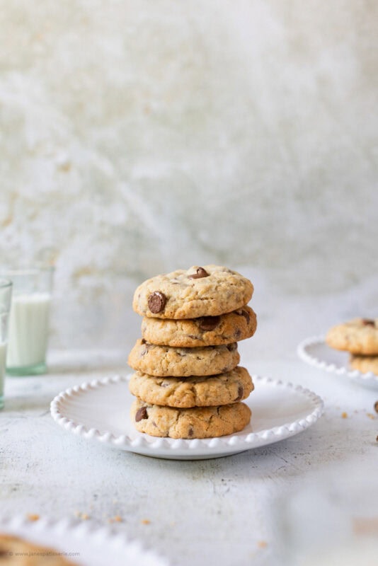 A stack of five chocolate oat cookies on a plate
