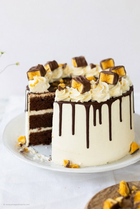 S slice missing from a whole crunchie Drip cake