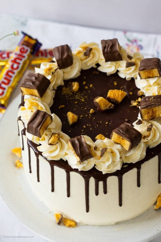 A Crunchie Drip Cake with Crunchies in the background