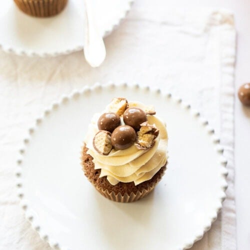 A high angle shot of a malteser cupcake on a plate