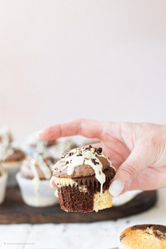 A hand holding a marble cupcake