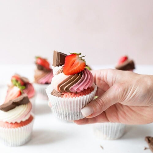 A hand holding a finished Neapolitan Cupcake