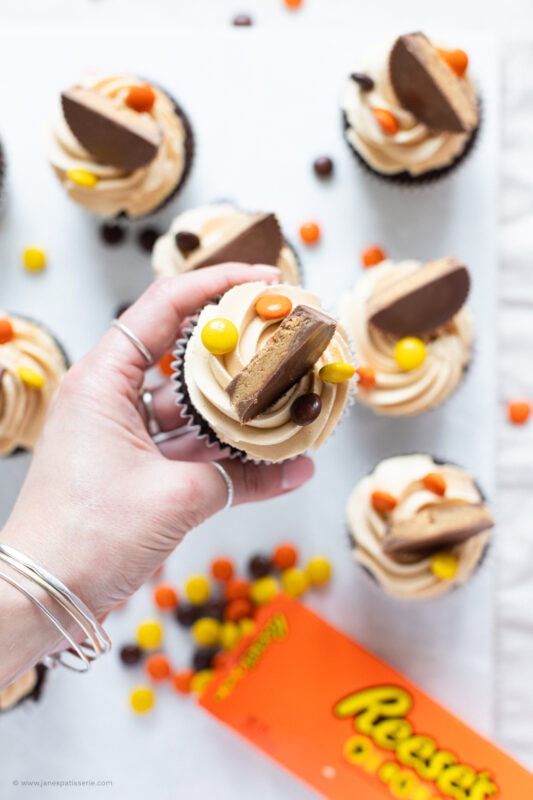 A hand holding a Reese's Peanut Butter Cupcake