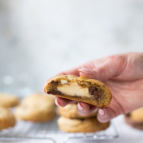 A hand showing the inside of a Salted Caramel Cheesecake Cookie
