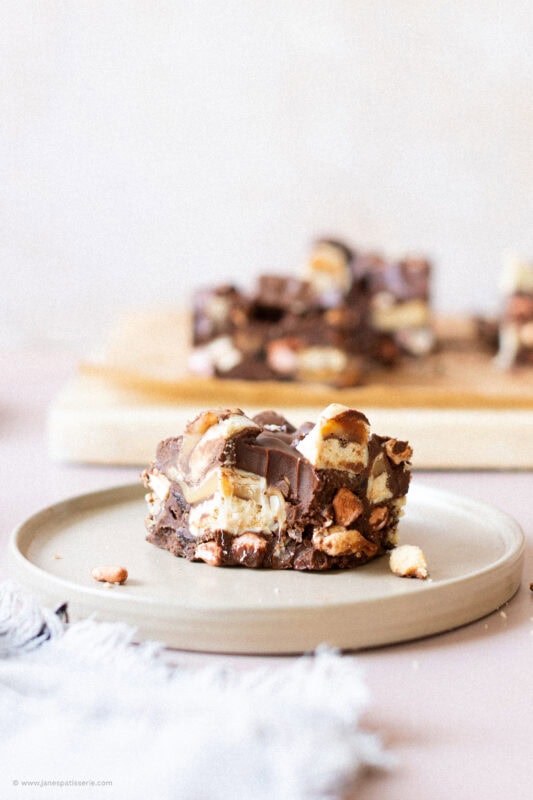 A bite missing from a square of Twix Rocky Road