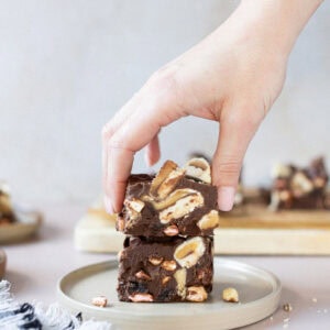 A hand taking a Rocky Road from a plate