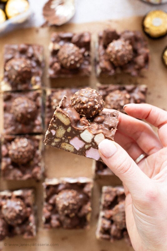 A hand holding a square of Nutella Rocky Road