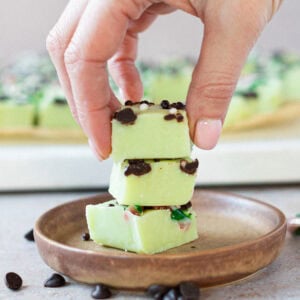 A hand placing a slice of Peppermint Fudge on a plate