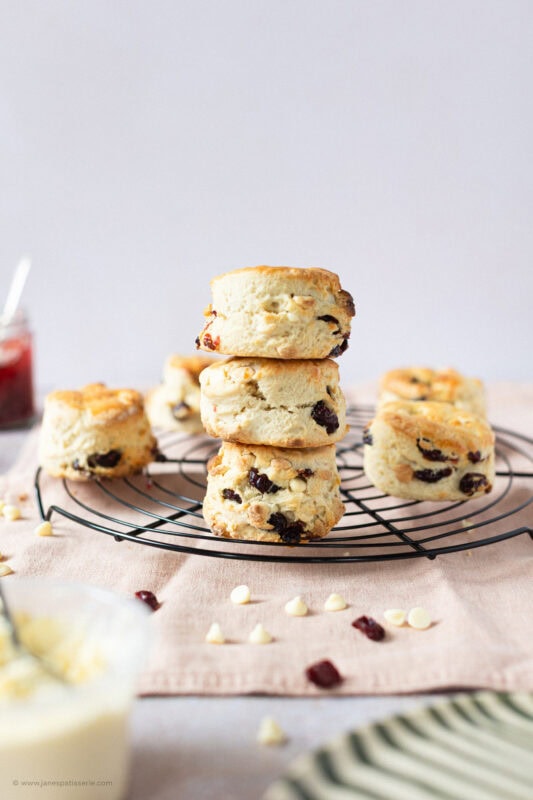 A stack of three White Chocolate and Cranberry Scones on a cooling rack