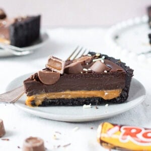 A slice of no-bake Rolo tart on a plate with a fork