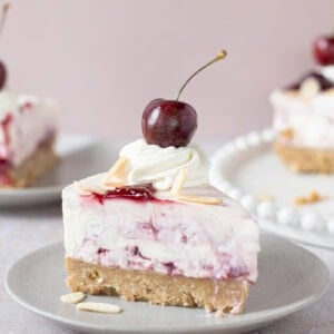 A slice of Cherry Bakewell Cheesecake on a plate