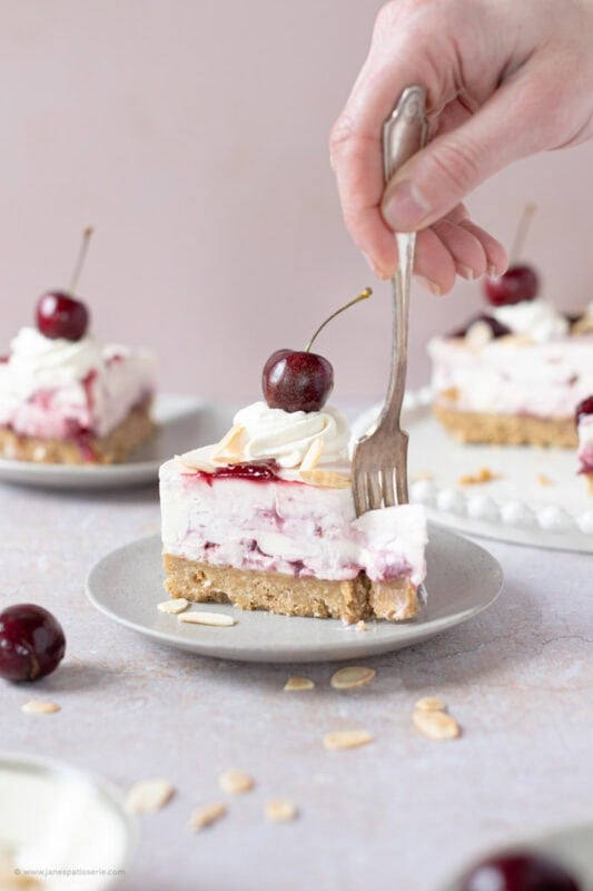 A fork cutting into a slice of Cherry Bakewell Cheesecake