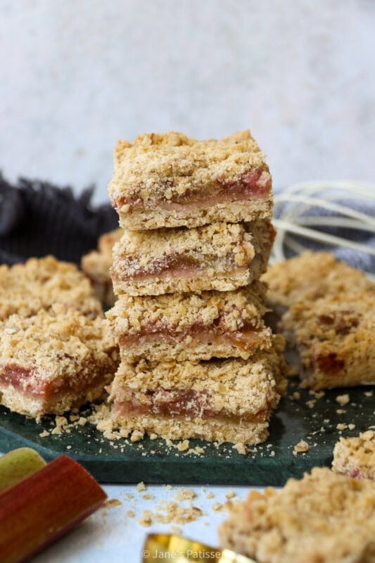 A stack of four Rhubarb Crumble Bars on a chopping board