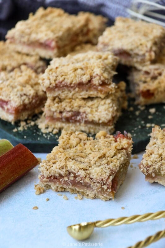 A Rhubarb Crumble Bar in front of the collection on a chopping board
