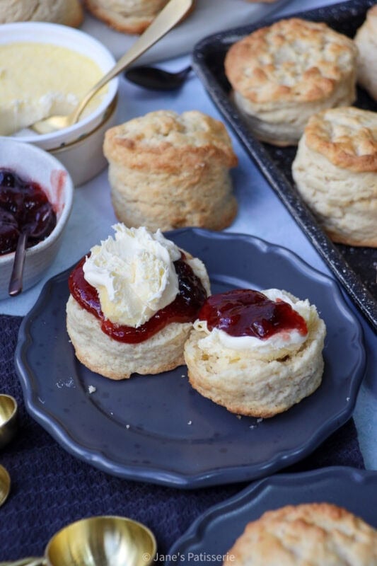 A Buttermilk Scone with jam and clotted cream on a plate