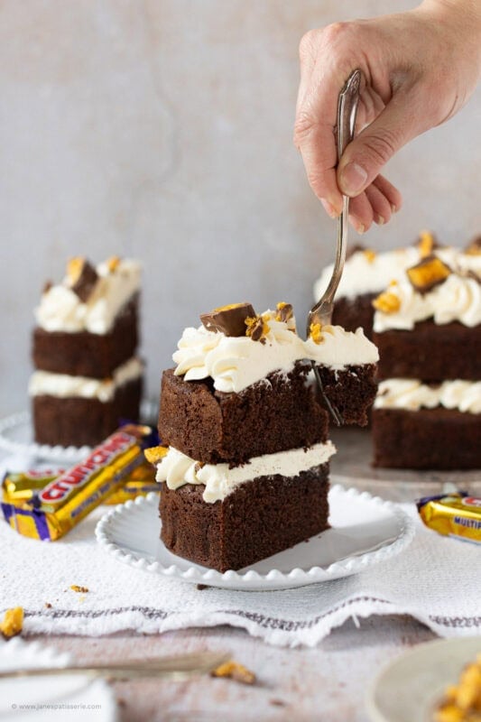A fork slicing into a Honeycomb Crunchie Cake slice