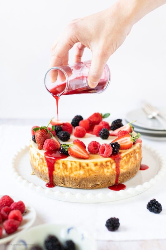 Final decorations and pouring coulis onto a New York Cheesecake